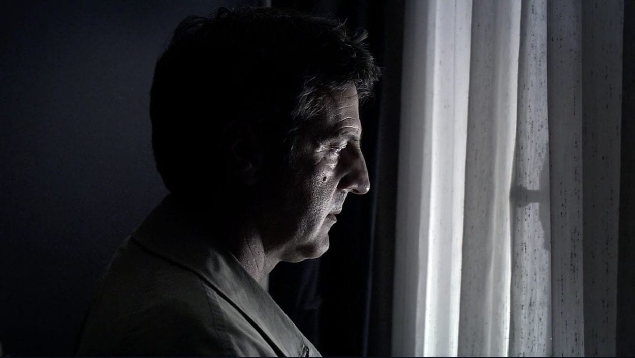 Georges (Daniel Auteuil) looks out onto the street to where his family is being watched