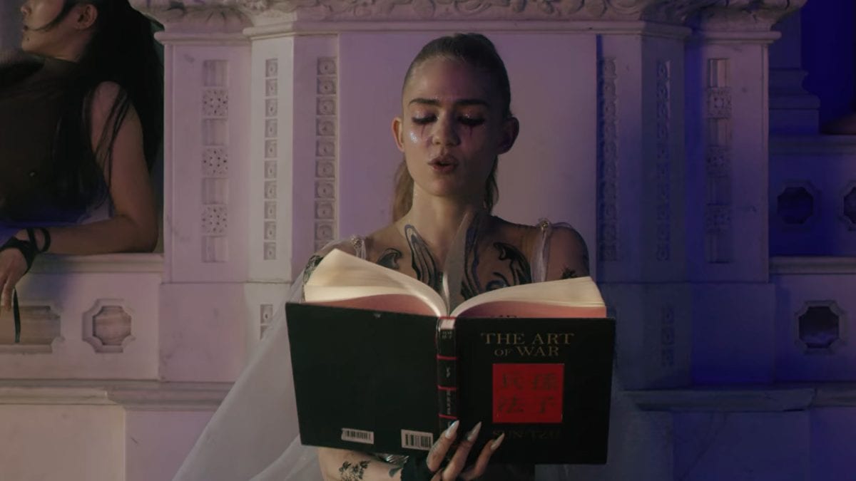 Grimes reads from a book in the opening to the video to Violence