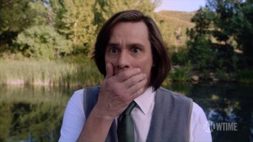 Jim Carrey stands in shock with his hand over his mouth