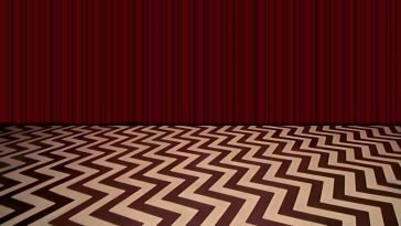 The Red Room from Twin Peaks with no furniture or people. Black and white zig-zagged floor and red curtain.