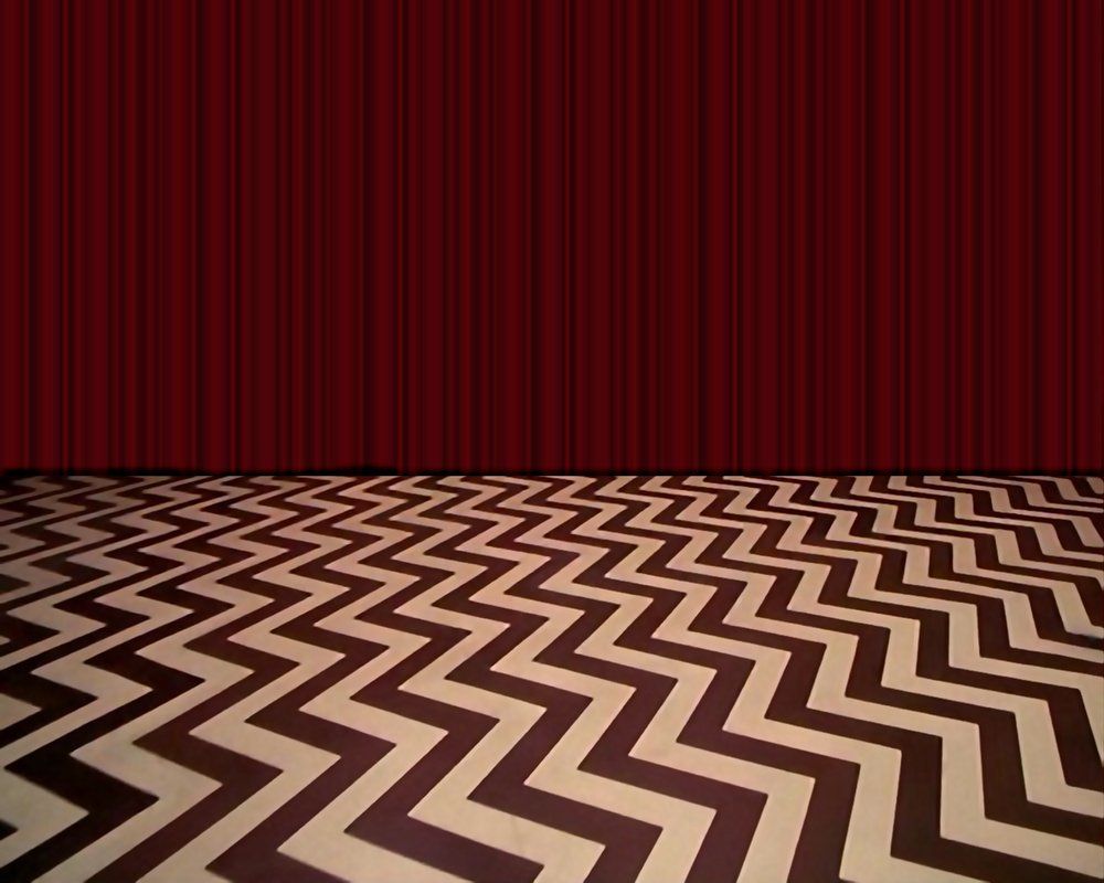 The Red Room from Twin Peaks with no furniture or people. Black and white zig-zagged floor and red curtain.