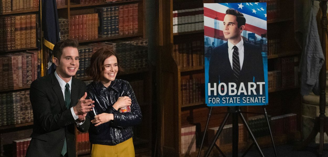 Payton and Infinity (Ben Platt and Zoey Deutch) stand in front of an audience during a speech for Payton's State Senate campaign.