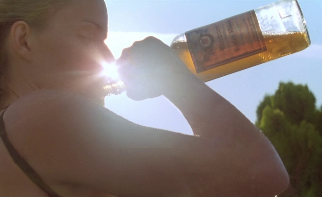 Sera takes a swig from a bottle of tequila