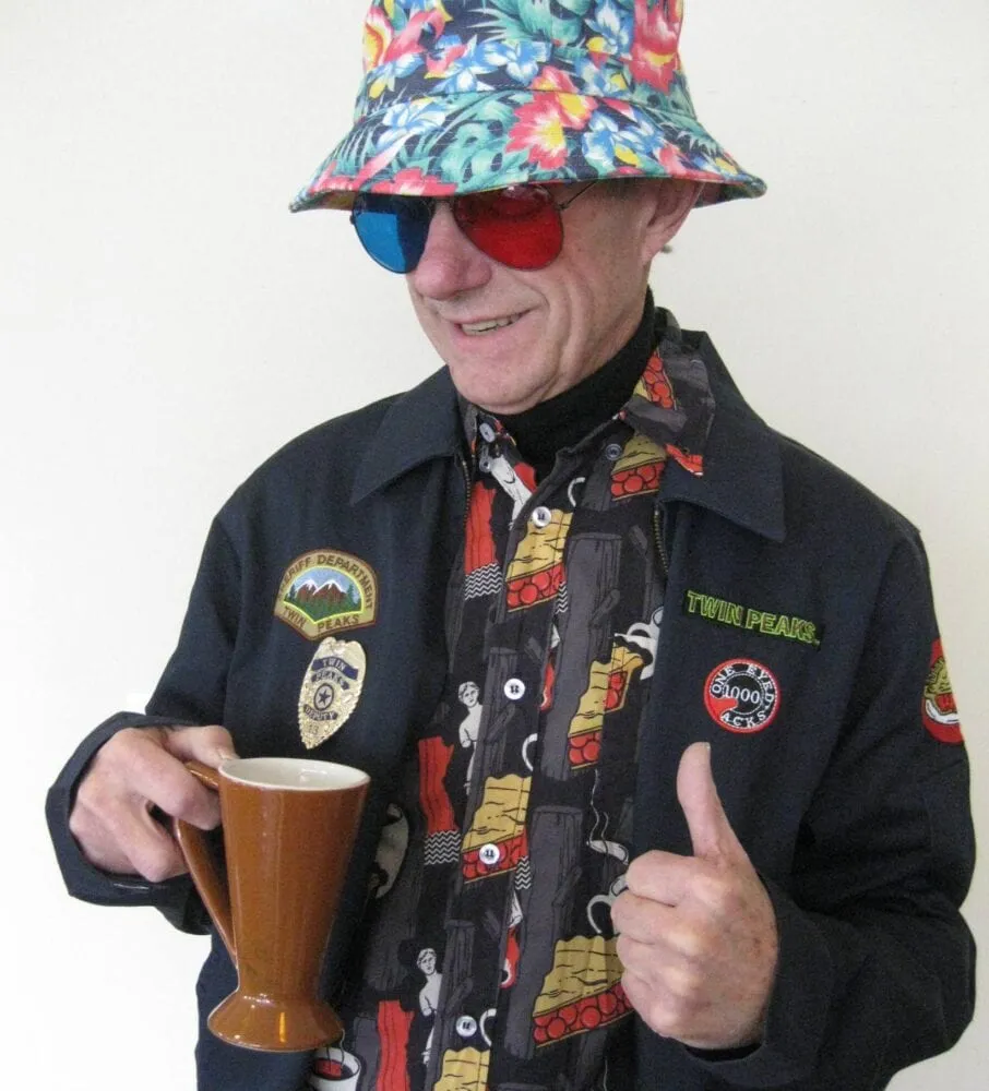 Bruce Phillips, dressed in Jacoby blue/red glasses, bucket hat, Twin Peaks hawaiian style shirt, and coat filled with Twin Peaks patches.