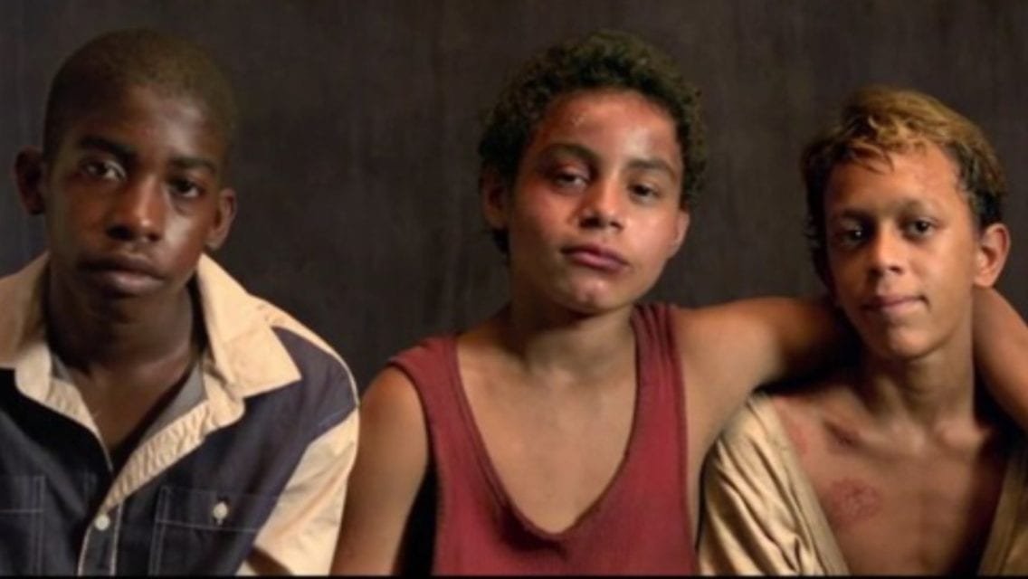 Gardo, Raphael sit next to Rato and Raphael has one arm around Rato