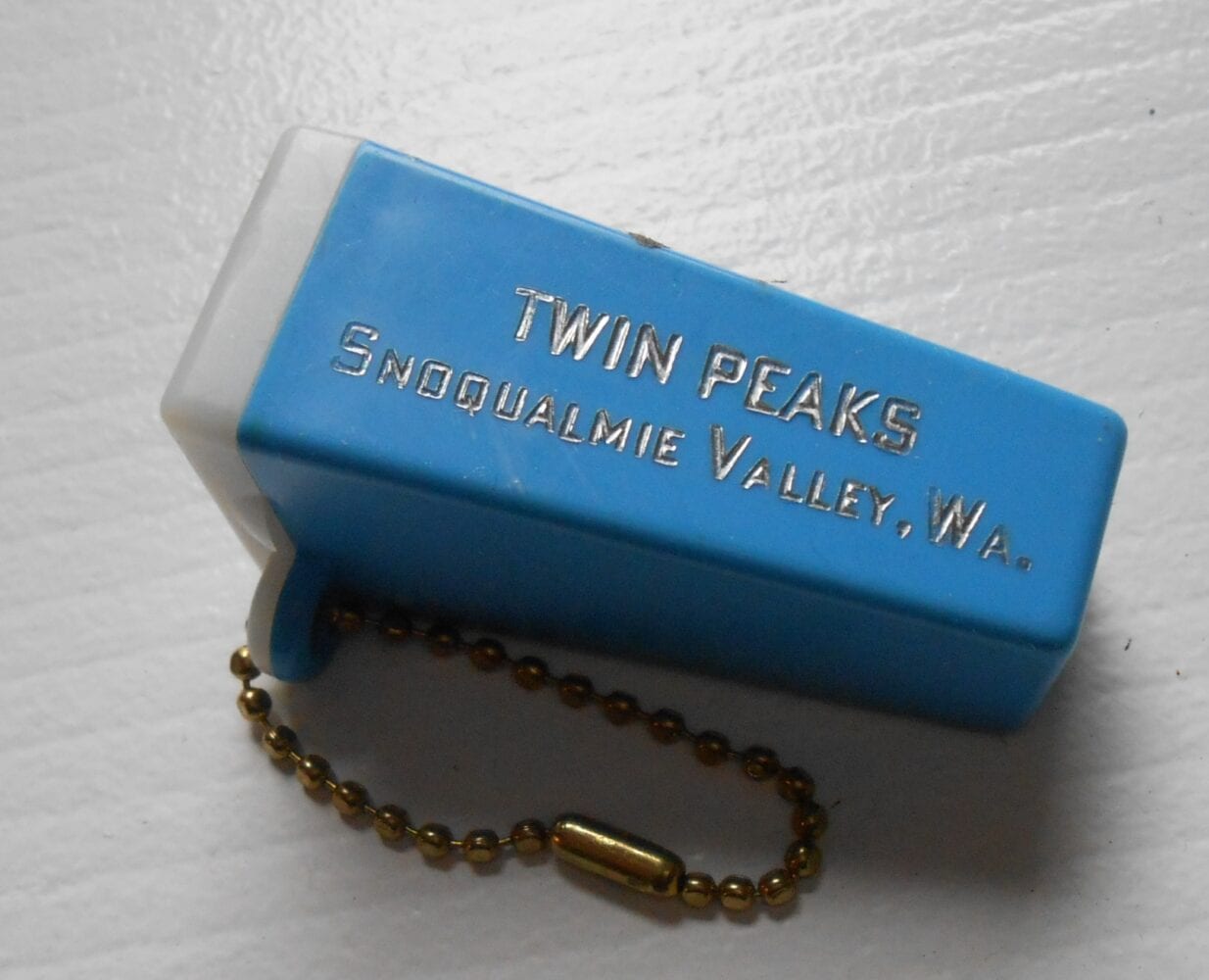blue single slide rectangular viewer the size of a keychain, embossed with "Twin Peaks Snoqualmie Valley, Wa" in gold.
