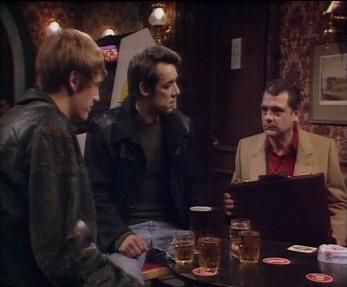 Rodney and Trigger stand around a pub table looking at Del 