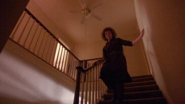 Sarah runs down the stairs under the fan