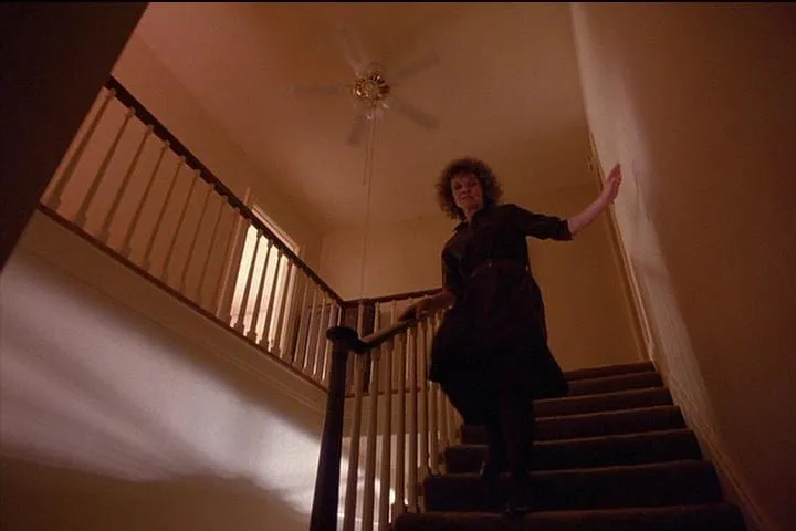 Sarah runs down the stairs under the fan