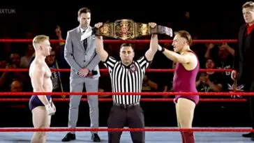 A ref holds up the NXT UK belt