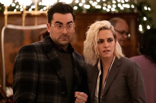 John raises his eyebrows next to Abby holding his arm.
