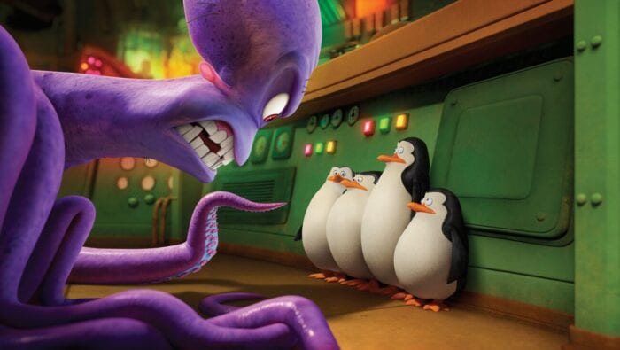 Penguins of Madagascar still featuring Dave, a large purple octopus baring his scraggly teeth at the four penguins (from left to right: Rico, Skipper, Kowalski, and Private). Each of the penguins appear confused, backed up against a green metal wall with a couple sets of red, green, and yellow lights, a vent, and some gages.