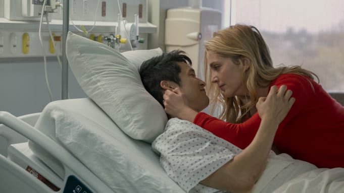 Jennifer lays with her husband Sol on a hospital bed.