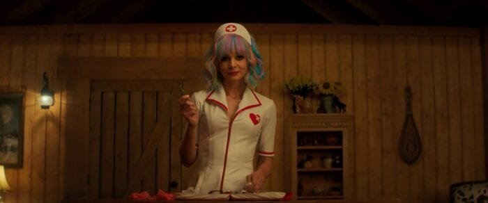 Cassie, dressed as a nurse, brandishes a scalpel.