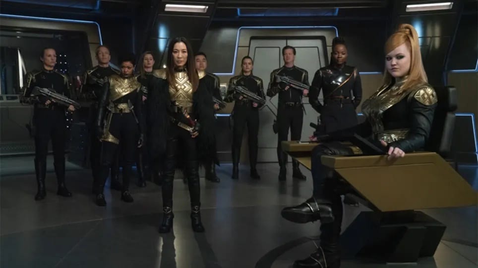Georgiou (Michelle Yeoh) stands at attention with the rest of the Mirror Universe crew while Captain "Killy" (Mary Wiseman) sits in the captain's chair