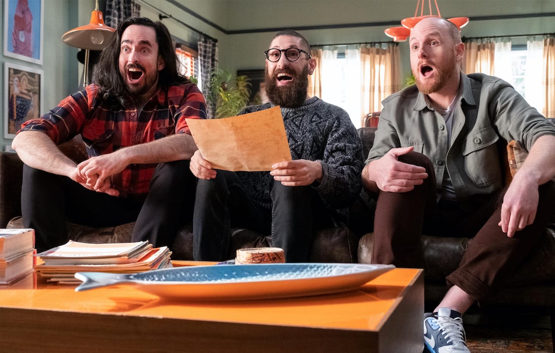 Aunty Donna sit on a couch looking excited