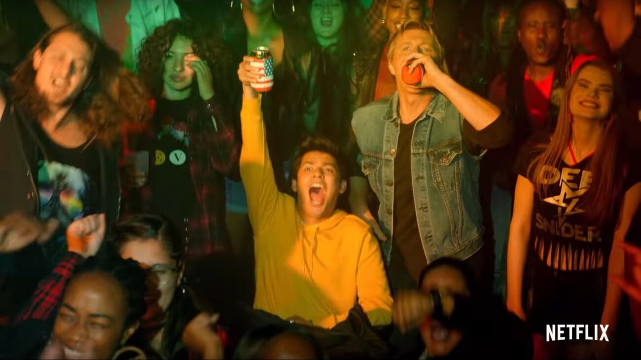 A crowd at a concert, many of whom are drinking, in Cobra Kai Season 3
