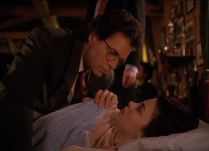 Audrey, recovering in a bed, tells her father--who is leaning close--that she knows he's into shady things.