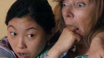 Awkwafina puts her fingers down Alison Janneys mouth while wrapping her other arm around her shoulder