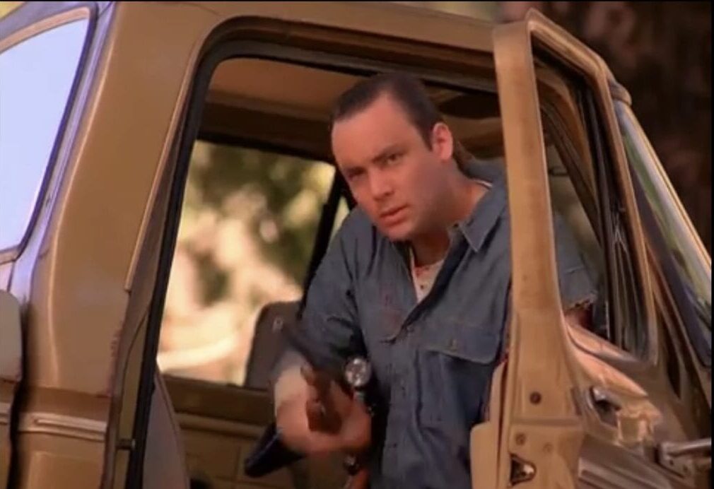 Leo takes a gun from inside his truck while sitting in the passenger seat with the door open in Twin Peaks Episode 6