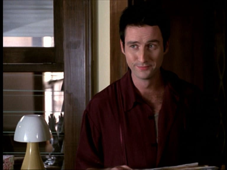 Doyle stands in the Angel Investigations office smiling