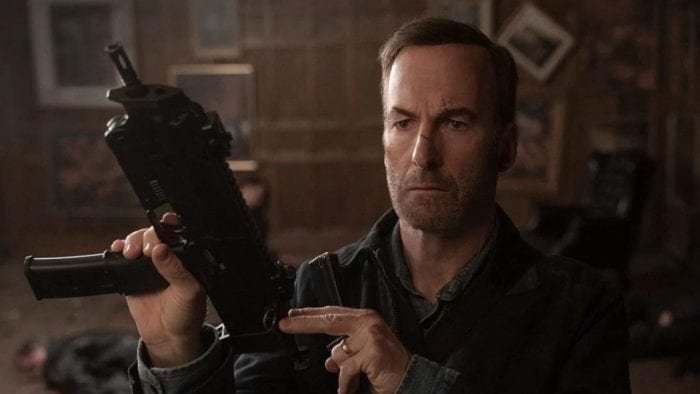 Hutch holds and cocks back a submachine gun.