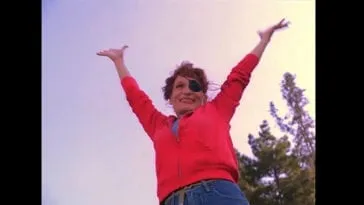 Nadine in red shirt raising arms to sky