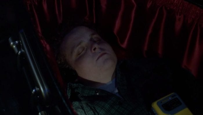 Ronnie sleeps in his coffin, headphones on