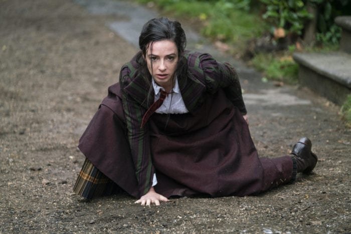 Amalia hunched to the ground with one hand upon it, after jumping in The Nevers Pilot, Touched
