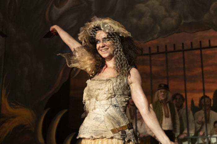 Maladie flourishes a hand into the air onstage at the opera house