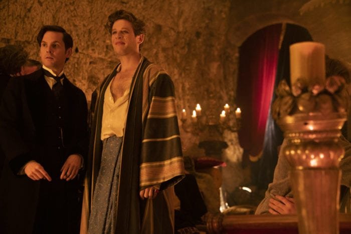 Hugo and Augustus stand next to each other at the Ferryman's party