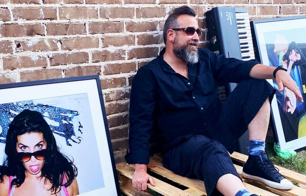 Gabriel Gornell sits outside next to a framed photo of Amy Winehouse