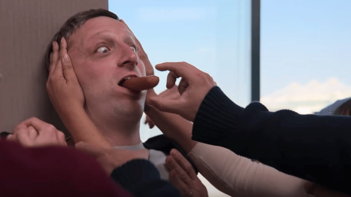 Tim Robinson is choking on a hot dog while pressed up against a wall in I Think You Should Leave Season 2