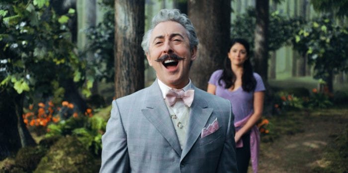 Mayor Menlove (Alan Cumming) sings as Mel (Cecily Strong) looks on