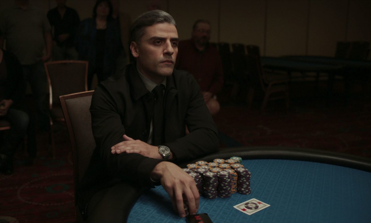 A gambler covets his stacks of chips at a card table.