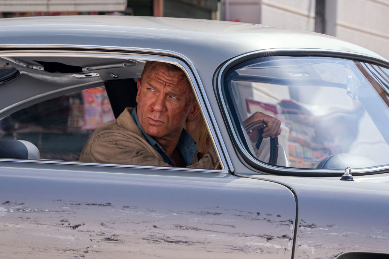 James Bond looks out his damaged car towards his pursuers.