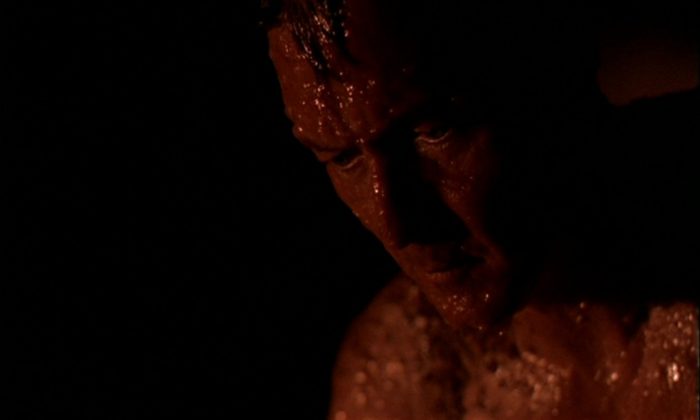 John Doggett, covered in slime, looks sad and thoughtful