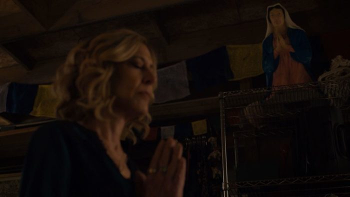 Sheryl prays beneath a statue of Virgin Mary.