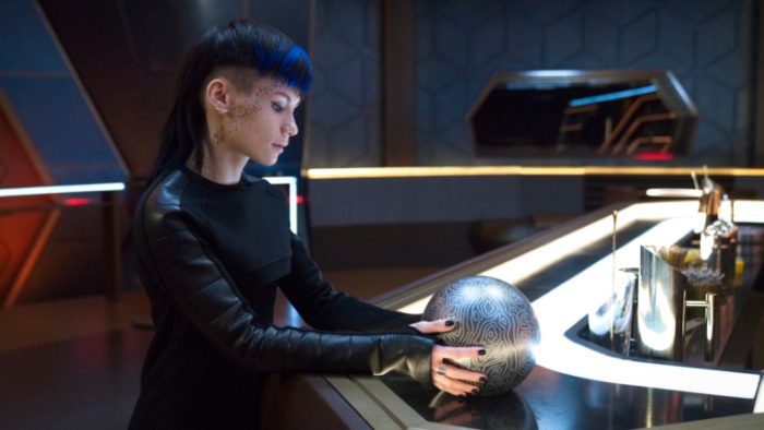 Grey (Ian Alexander) holding a grey orb in the Discovery bar