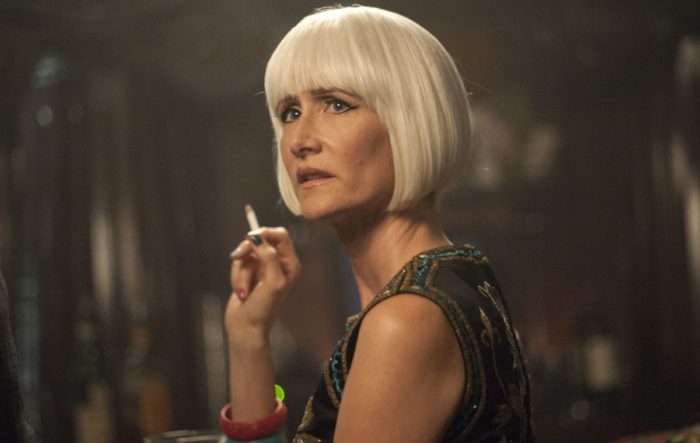 Diane (Laura Dern) in a white wig holding a cigarette, looking toward the side