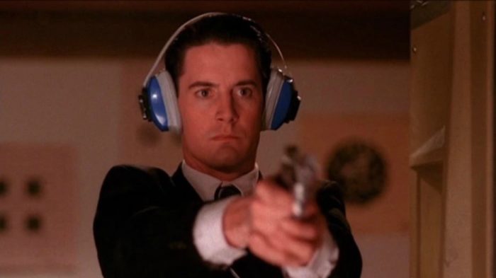 Twin Peaks - Dale, wearing protective ear muffs, stands at a firing range with gun held firmly in front of him