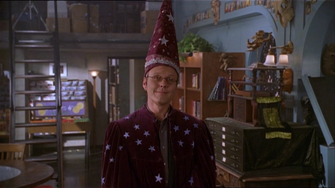 Giles dressed as a wizard in his magic shop, looking very pleased with himself