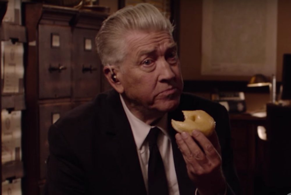 David Lynch as Gordon Cole, eating a donut and sitting in front of a vintage filing cabinet