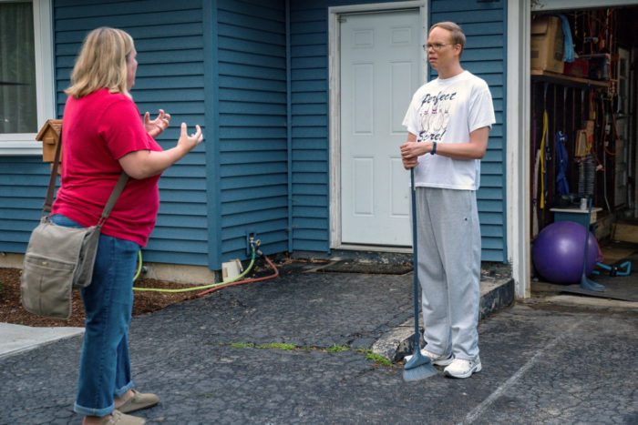 Sam and Joel stand in his driveway as she beseeches him with her hands