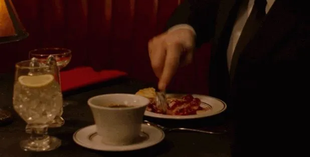 a glass of water, a glass of coffee, and a slice of pie being sliced on an ornate table