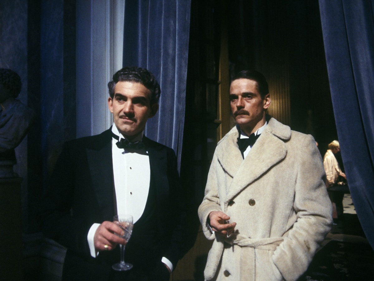 Rex Mottram (Charles Keating) and Charles Ryder (Jeremy Irons) dressed for dinner, and frowning, as they discuss the quirky and unfathomable Marchmains. From the 1981 Granada (ITV) production of Brideshead Revisited.