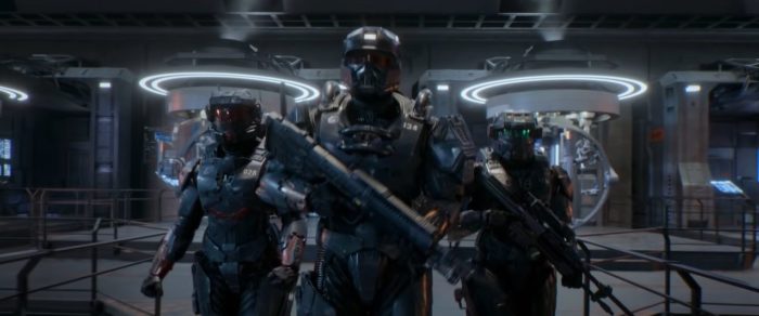 Soliders stand wearing armor and holding long guns in Halo S1E1, "Contact"
