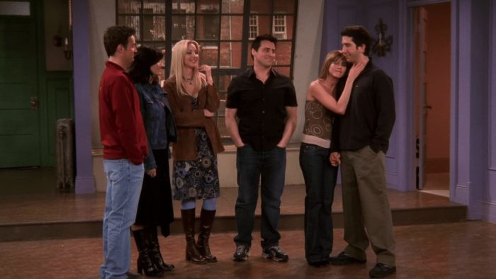 Chandler, Monica, Phoebe, Joey, Rachel, and Ross, stand in an empty apartment smiling at each other