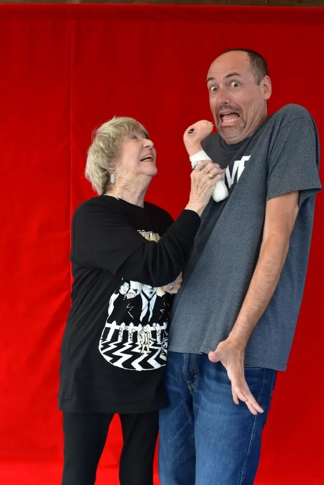 Charlotte Stewart with Eraserhead baby and Scott in front of red curtains