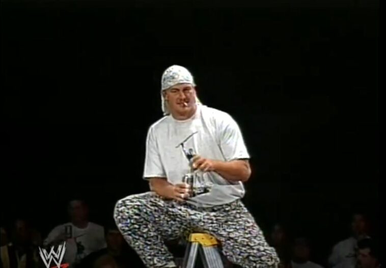 Mikey Whipwreck sits on a ladder
